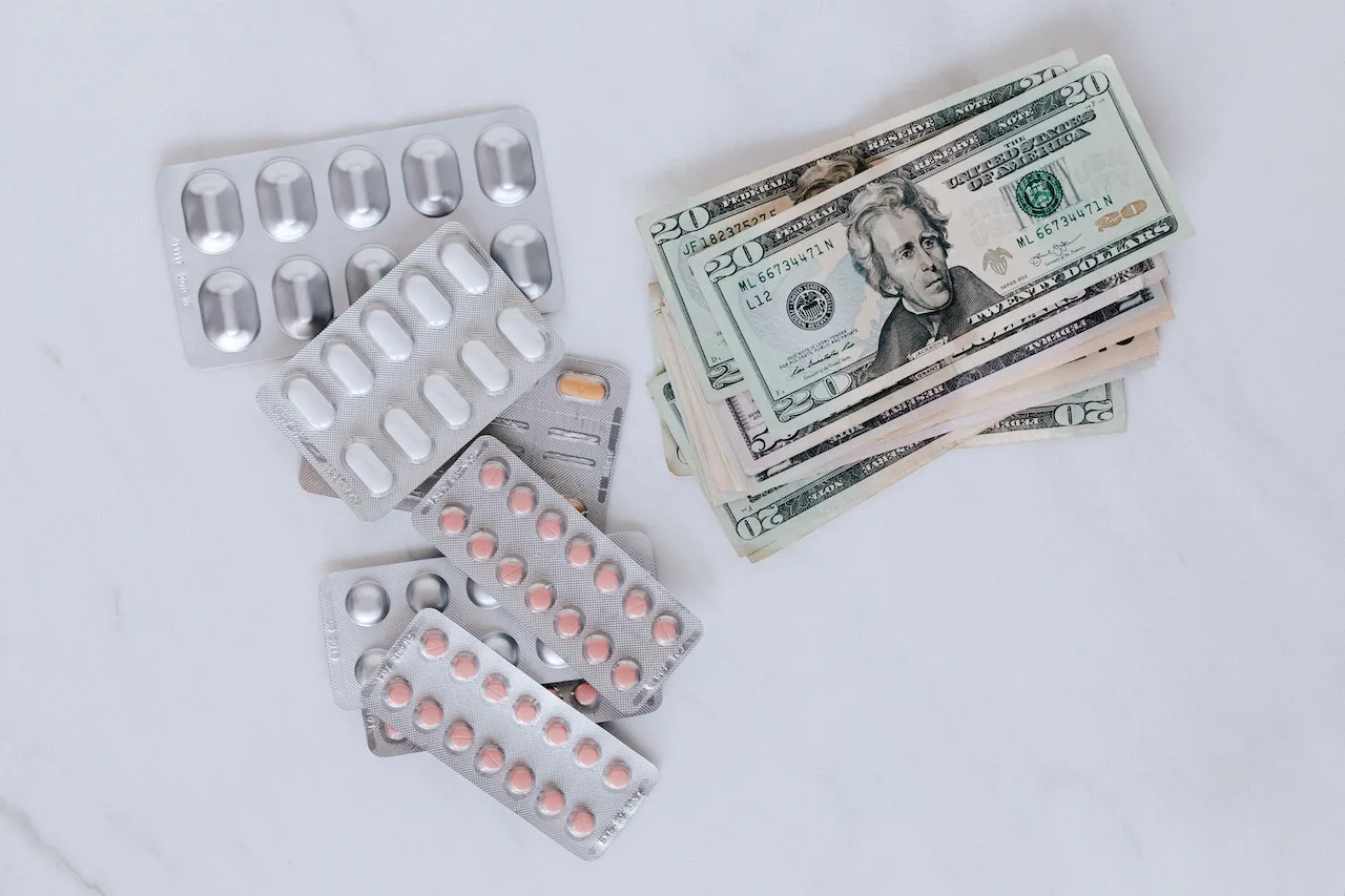 picture of drugs and dollar bills on a white table.