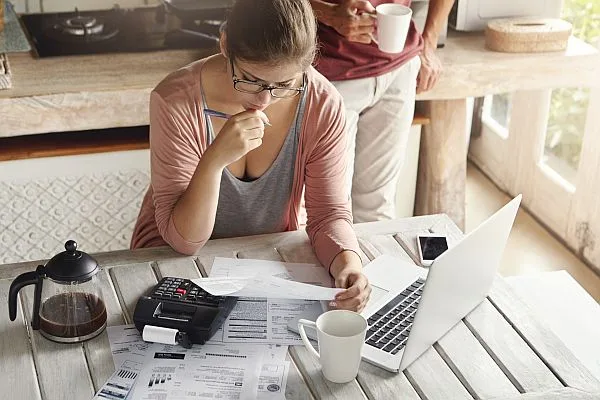 couple looking over bills at breakfast table